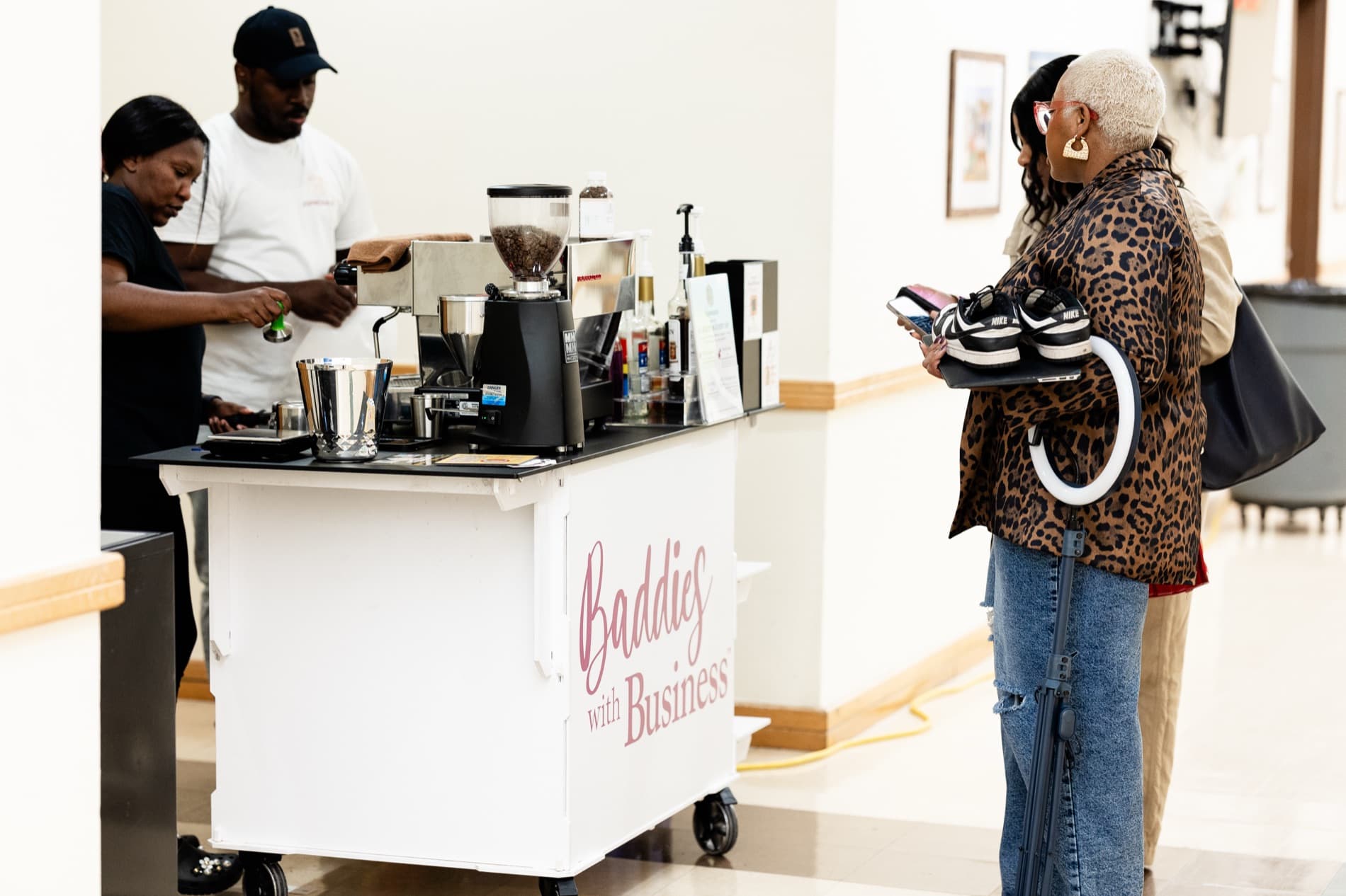The Espréssate coffee cart wrapped in a client's Baddies with Business branding, serving guests at a brand activation
