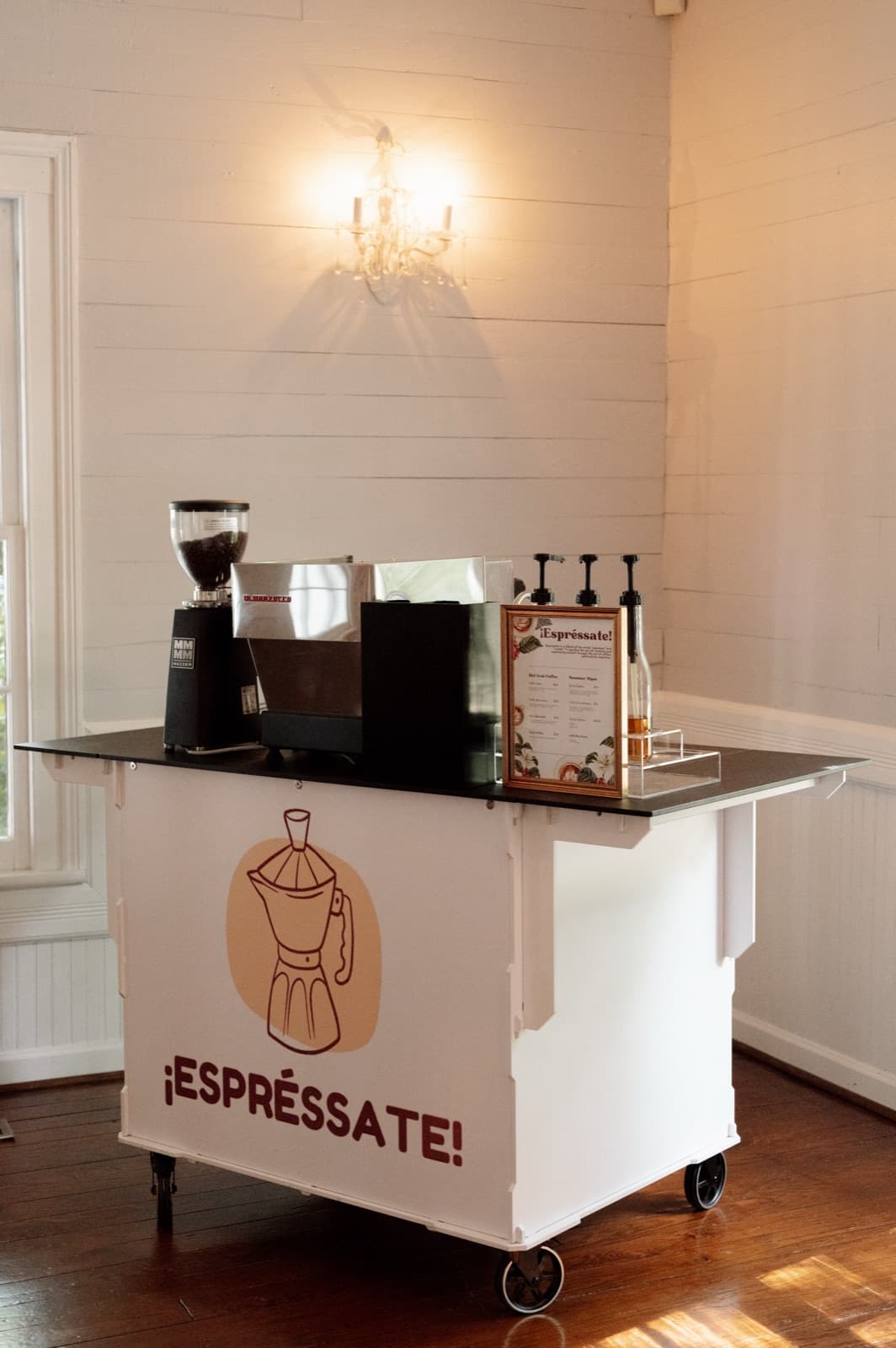 The Espréssate mobile espresso bar cart set up under a chandelier at a Durham, NC event venue